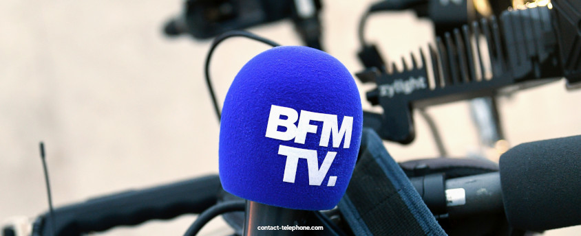 Micro de BFM TV devant une caméra de télévision.