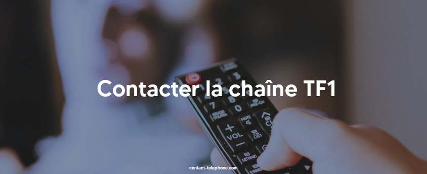 Main d'une femme tenant une télécommande devant un poste de télévision.