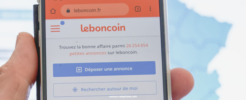 Main tenant un téléphone portable affichant l'application Leboncoin.