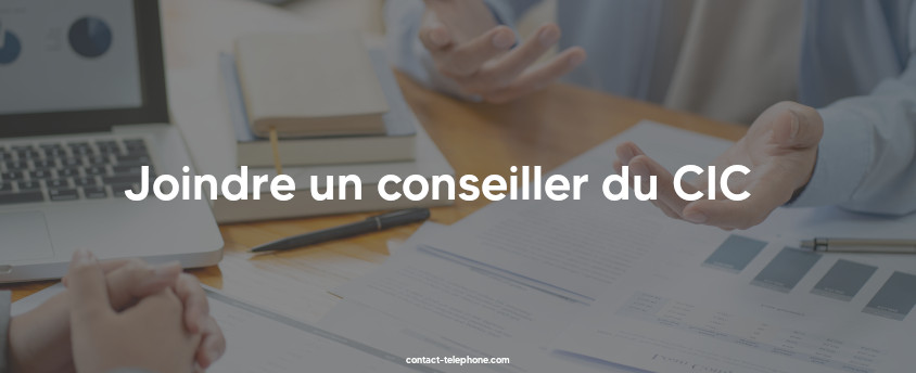 Mains de deux personnes discutant autour d'une table sur laquelle sont posés un ordianteur, un stylo, des contrats, entre autres.