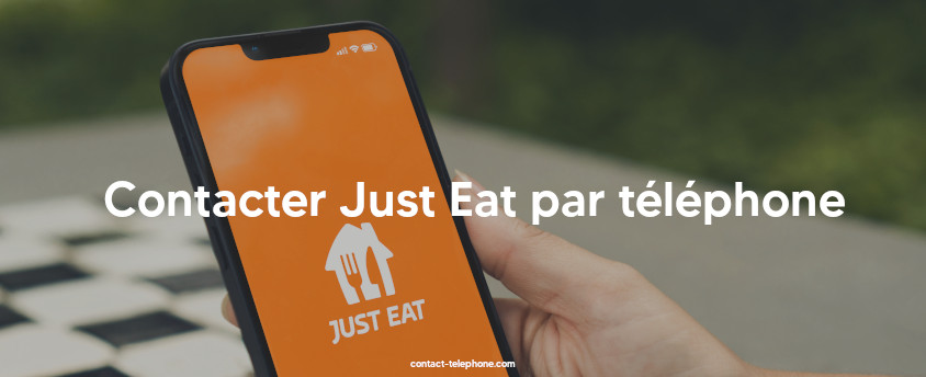 Téléphone, affichant le logo de l'application Just Eat, tenu dans une main.
