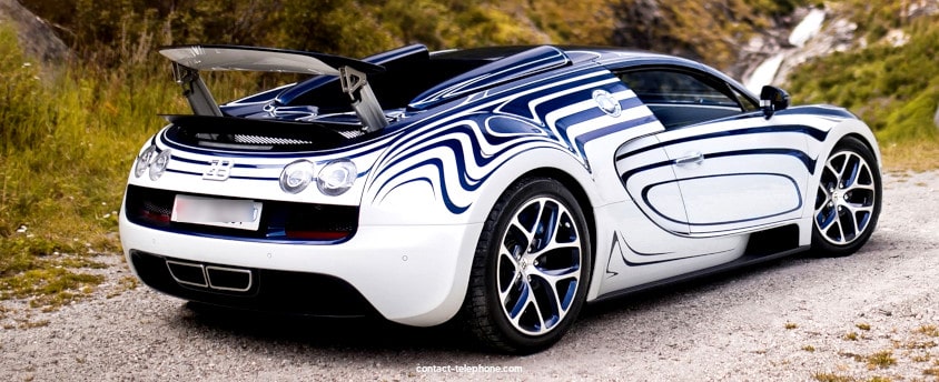 Arrière d'une voiture Bugatti vu de profil sur un chemin en montagne. 