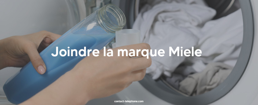 Main d'une femme mettant de la lessive dans une machine à laver le linge.