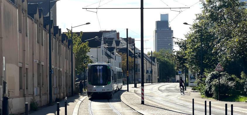 Tramde Nantes circulant sur une ligne, on aperçoit la tour de Bretagne en fond.