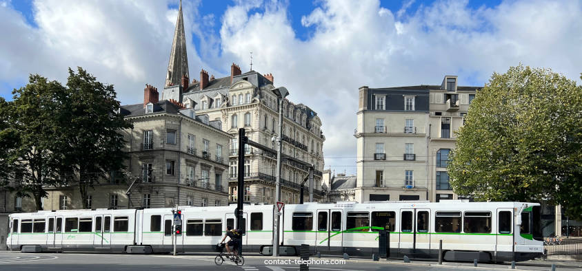 Tram et cycliste passant devant dans la ville de Nantes.